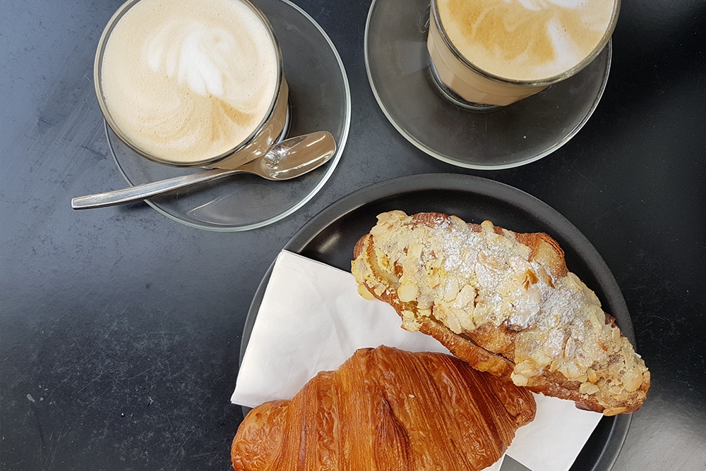 photo of 2 coffees and a croissant